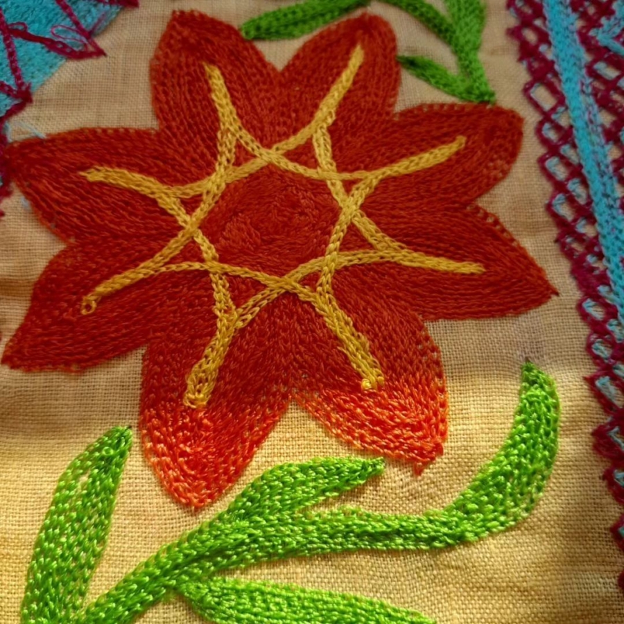Una flor bordada sobre la tela de huipil del Mixe Bajo, Oaxaca